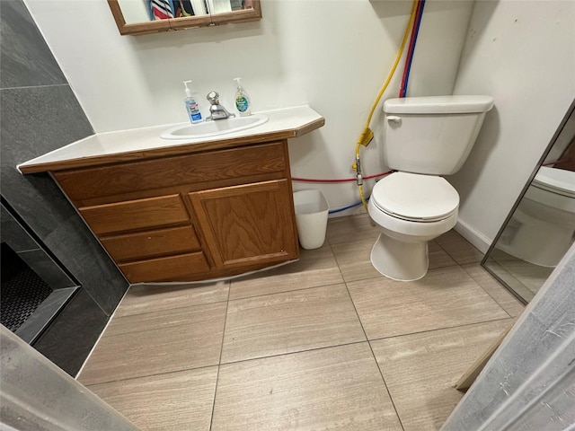 bathroom featuring toilet, tile patterned flooring, and vanity