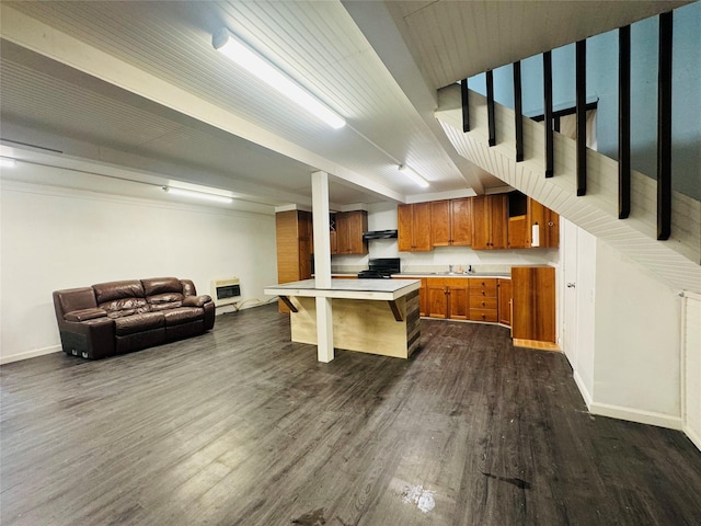 kitchen featuring a breakfast bar, dark wood-style flooring, brown cabinets, open floor plan, and black stove