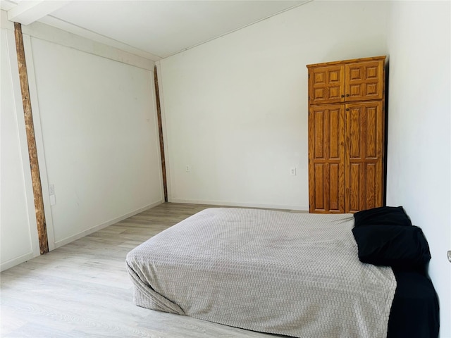 bedroom with light wood-style flooring and baseboards