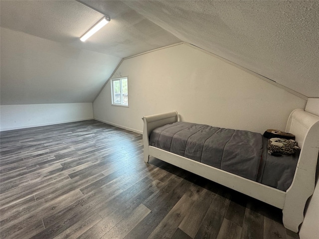 bedroom with a textured ceiling, baseboards, wood finished floors, and lofted ceiling