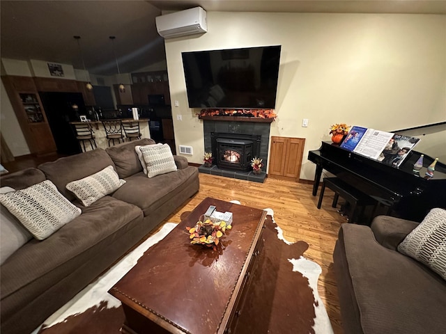 316 3rd Ave, Saint Ignatius, MT 59865 - living room with a wall mounted air conditioner, wood finished floors, lofted ceiling, and a fireplace