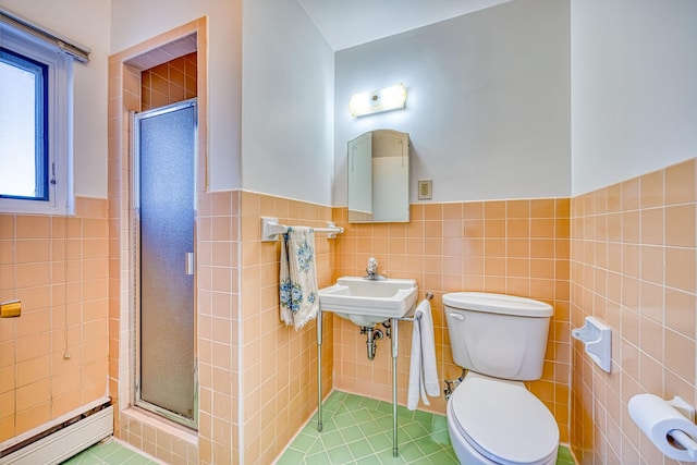 full bathroom with a baseboard heating unit, a stall shower, toilet, and tile walls