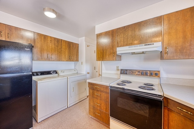 kitchen with range with electric stovetop, brown cabinetry, freestanding refrigerator, separate washer and dryer, and under cabinet range hood