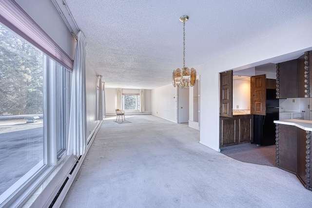 kitchen featuring a baseboard radiator, carpet, light countertops, a textured ceiling, and a notable chandelier