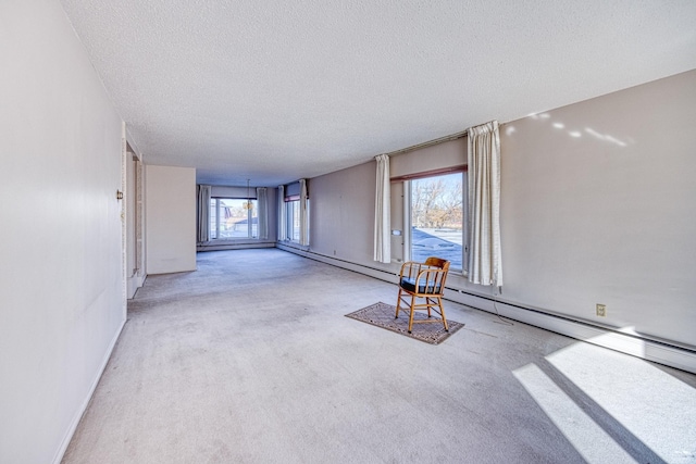 interior space featuring carpet floors, baseboard heating, a textured ceiling, and baseboards