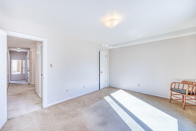 interior space featuring light carpet and baseboards