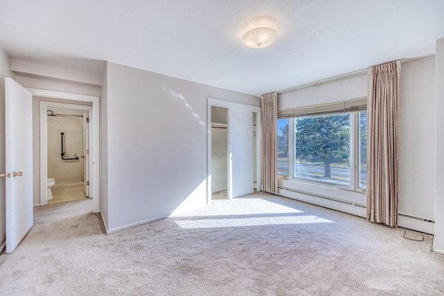 unfurnished bedroom featuring a closet, baseboard heating, and carpet flooring