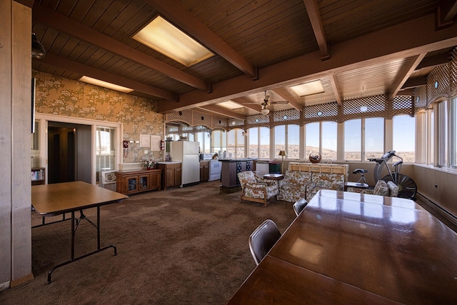 interior space with dark colored carpet, wood ceiling, and beamed ceiling