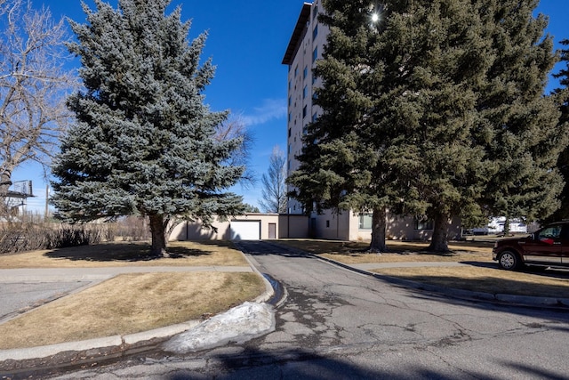 obstructed view of property with aphalt driveway