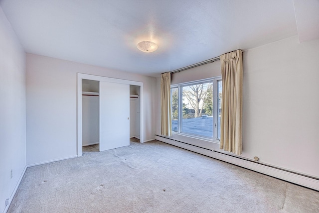 unfurnished bedroom featuring carpet floors, a closet, a baseboard radiator, and baseboards