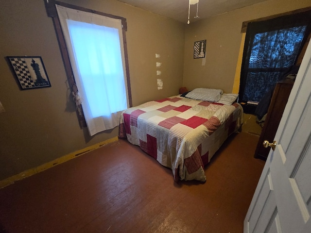 bedroom featuring baseboards and wood finished floors