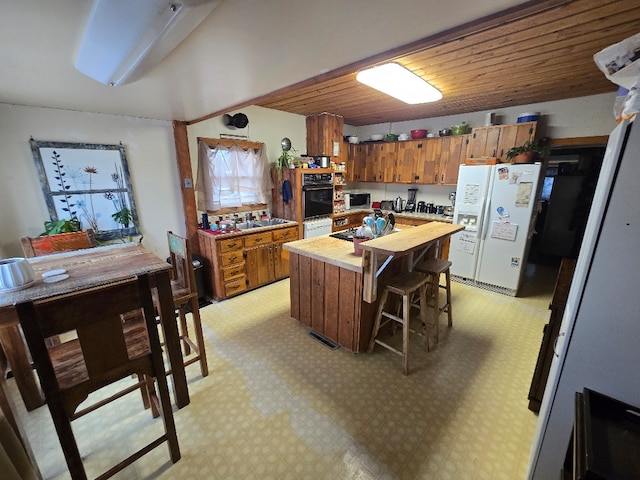 kitchen featuring brown cabinets, light floors, wood counters, white fridge with ice dispenser, and oven