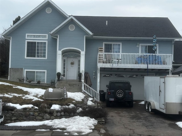 split foyer home featuring driveway, a shingled roof, and an attached garage