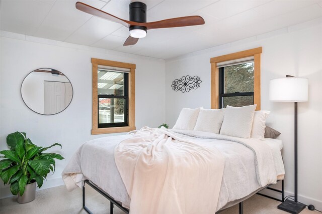 bedroom with baseboards, multiple windows, and carpet