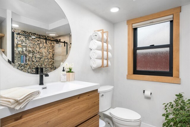 bathroom featuring a shower stall, toilet, vanity, and baseboards