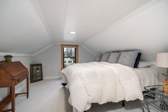 carpeted bedroom featuring lofted ceiling and baseboards