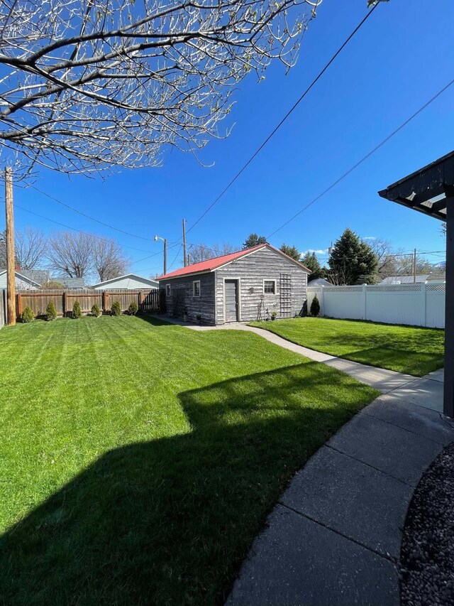 view of yard with a fenced backyard and an outdoor structure