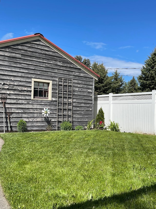 view of side of home featuring a yard and fence