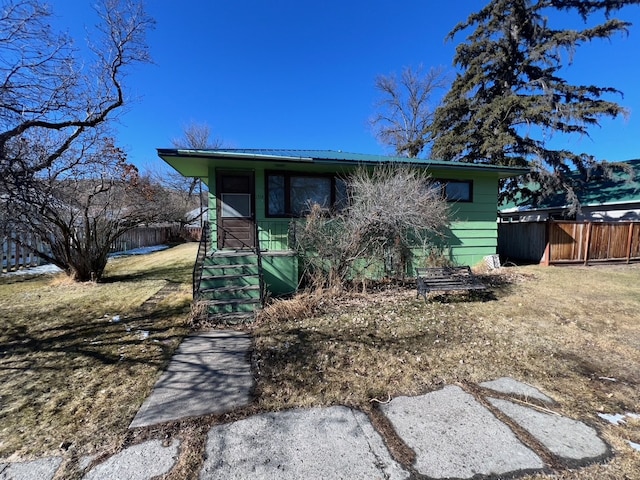 view of front of property with metal roof and fence