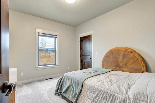 carpeted bedroom with visible vents and baseboards