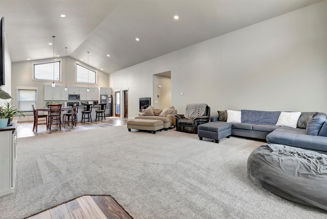 living area with high vaulted ceiling, carpet, wood finished floors, and recessed lighting