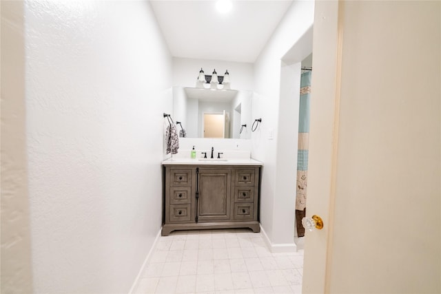 full bath with a shower with curtain, vanity, and baseboards