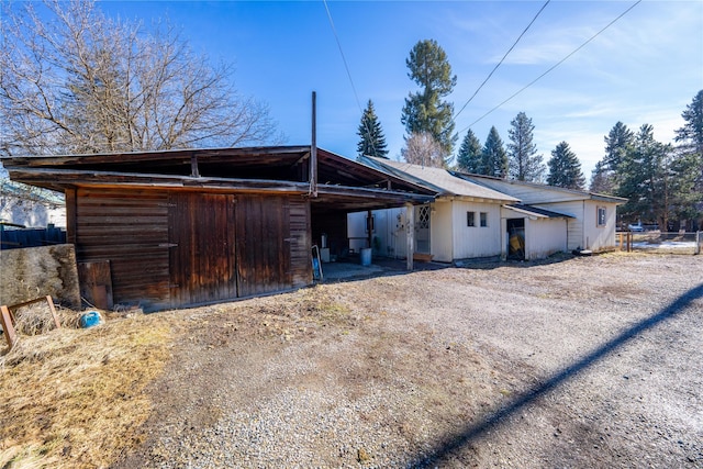 rear view of property with driveway and a carport