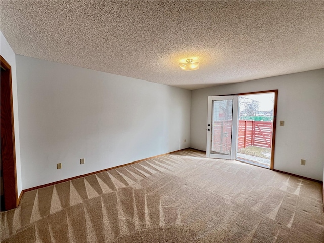 empty room with baseboards, a textured ceiling, and light colored carpet