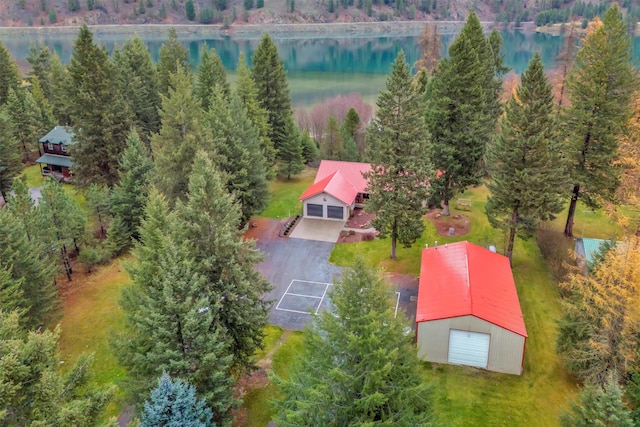 birds eye view of property featuring a forest view and a water view