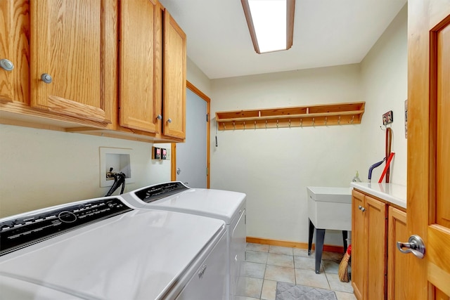 clothes washing area with baseboards, cabinet space, washing machine and clothes dryer, and light tile patterned floors