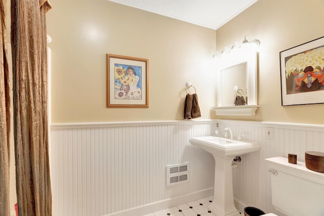 bathroom featuring toilet, a wainscoted wall, visible vents, ornamental molding, and tile patterned floors