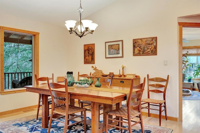 dining area with visible vents, a notable chandelier, baseboards, and wood finished floors