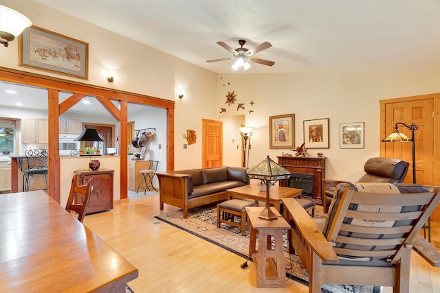 living room featuring light wood-style floors, vaulted ceiling, and ceiling fan