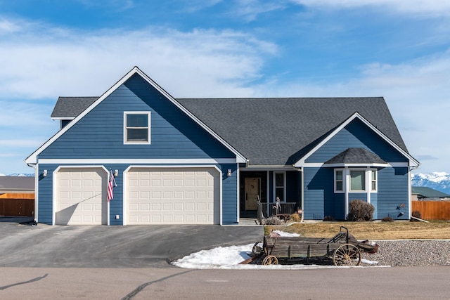 view of front of property featuring driveway, roof with shingles, and fence