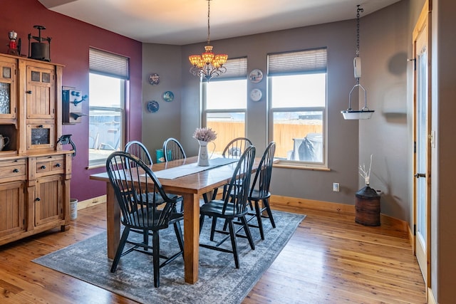 dining area with a notable chandelier, light wood-style flooring, and a healthy amount of sunlight