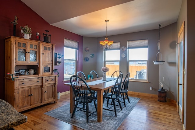 dining area featuring light wood-style floors, baseboards, and a chandelier