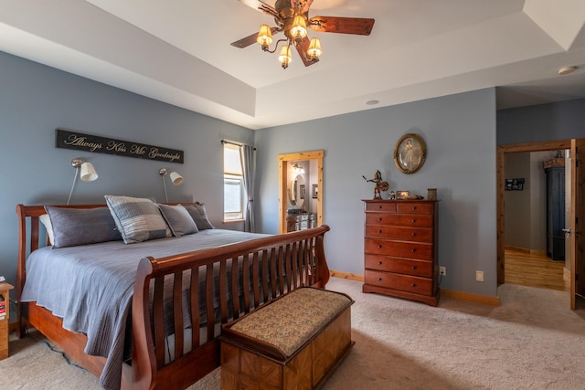 bedroom featuring ceiling fan, carpet, a raised ceiling, and baseboards