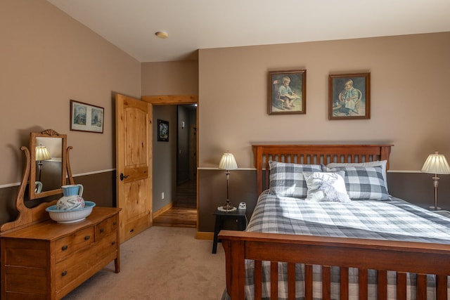 bedroom with baseboards and light colored carpet