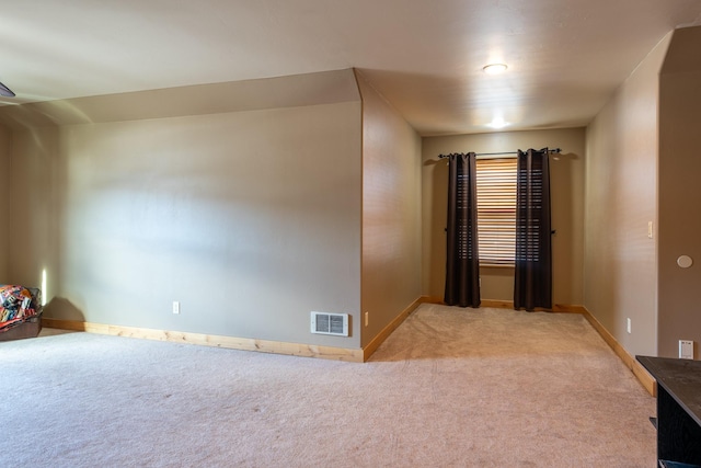 carpeted empty room featuring baseboards and visible vents