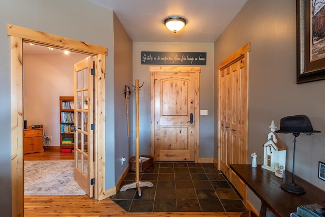 foyer entrance featuring baseboards and wood finished floors