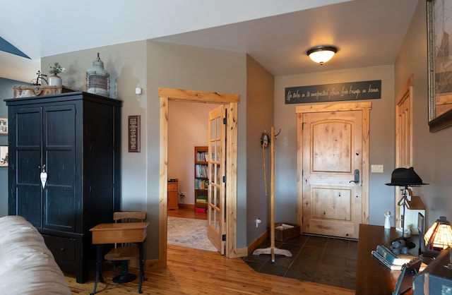 foyer with baseboards and wood finished floors