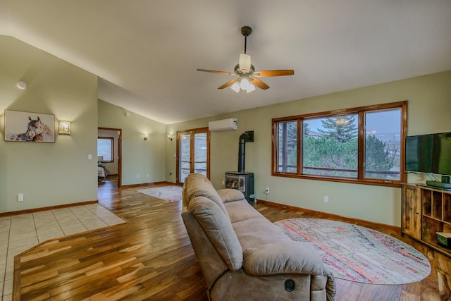 living area with plenty of natural light, a wood stove, vaulted ceiling, and a wall mounted AC