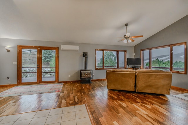 unfurnished living room featuring lofted ceiling, a ceiling fan, a wall mounted AC, wood-type flooring, and a wood stove