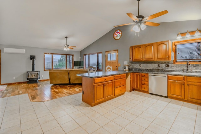 kitchen featuring a wall mounted AC, brown cabinetry, open floor plan, a sink, and dishwasher