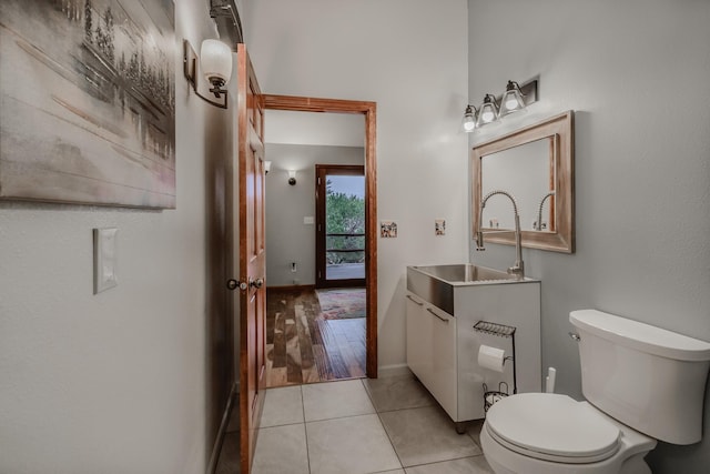 bathroom with toilet, vanity, baseboards, and tile patterned floors