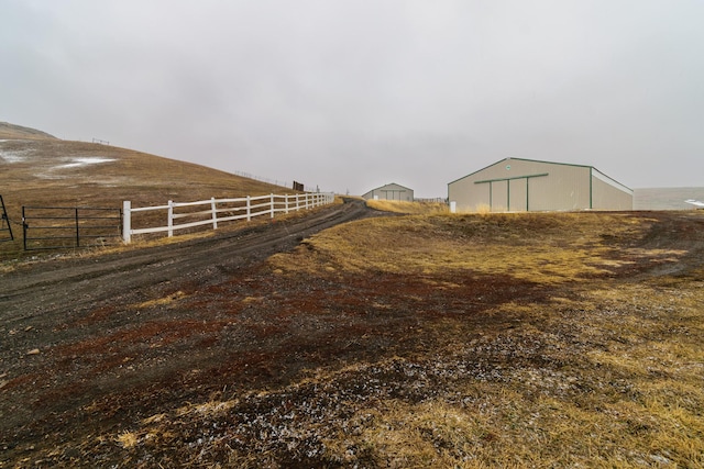 view of yard featuring an outbuilding, a pole building, and fence