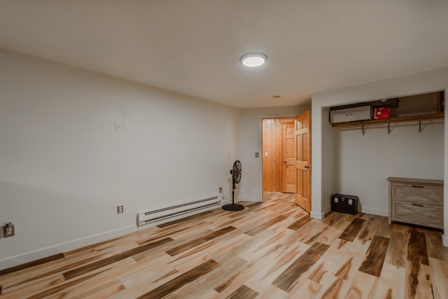 interior space with baseboards, baseboard heating, and wood finished floors