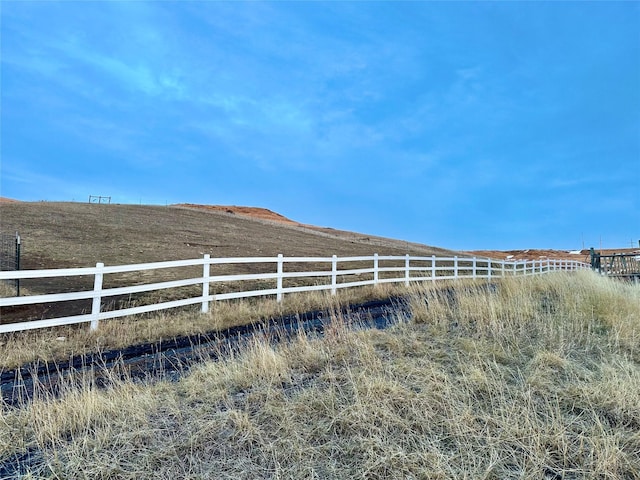 view of yard with fence and a rural view