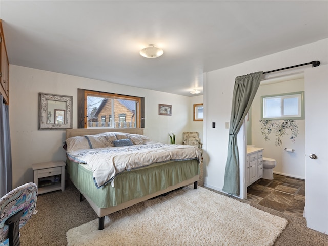 bedroom with multiple windows, connected bathroom, and baseboards