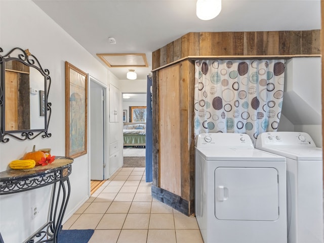 washroom with light tile patterned floors, attic access, and washer and dryer